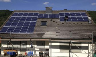 Specialist in uniform with tools and housewife washing machine